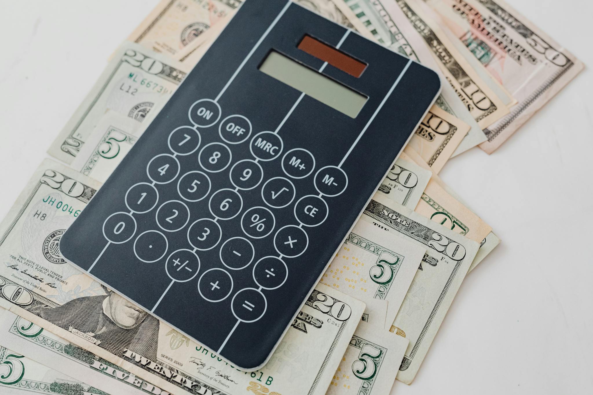 Close-up of a calculator atop US dollar bills, symbolizing financial planning and budgeting.